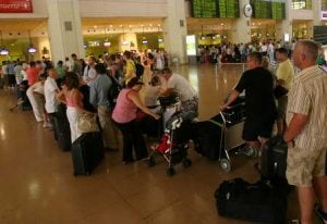 Pasajeros esperan facturar sus equipajes en un mostrador del aeropuerto de Málaga. / SUR