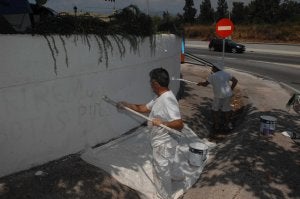 Trabajadores del hotel blanquean las paredes exteriores. ::                             JOSELE-LANZA