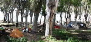 Tiendas de campaña, fogatas para cocinar y enseres por el suelo conforman el escenario actual en el antiguo camping anexo al balneario. ::                             ÁLVARO CABRERA