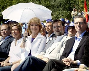 Esperanza Aguirre, flanqueada por Ana Mato y Rajoy, se protege del sol. ::
ALBERTO MARTÍN / EFE