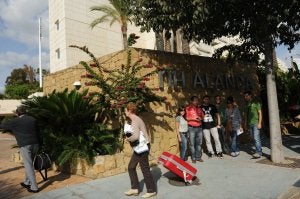 Dos clientes flanquean la entrada del hotel ante la mirada de algunos de los trabajadores despedidos. ::
JOSELE-LANZA