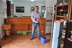 El alcalde de El Borge, Salvador Fernández (PSOE), posa con una fregona entre las manos en el Ayuntamiento. A. Peláez