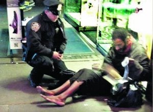 El policía Larry DePrimo, en la imagen captada por el móvil de una turista, mientras el mendigo abre la caja de las botas. ::
SUR