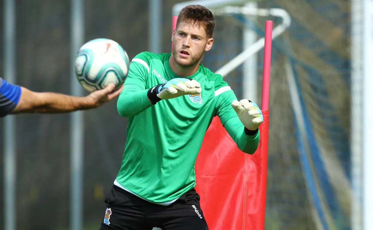 Álex Remiro, concentrado en el balón durante un ejercicio en una sesión de entrenamiento.