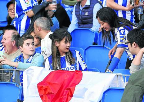 Imagen secundaria 1 - Miembros de la peña Reala Nippon en Yokohama. Dos seguidoras asiáticas en el Reale Arena y simpatizantes japoneses de la Real con aficionados locales en Anoeta.