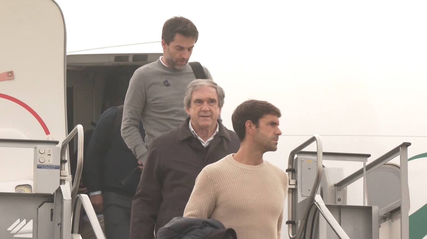 Imagen principal - Xabi Prieto y Luis Arconada bajan las escaleras del avión; Mikel Merino se dispone a subir al autobús; y Eneko Goia, parte de la expedición del club.