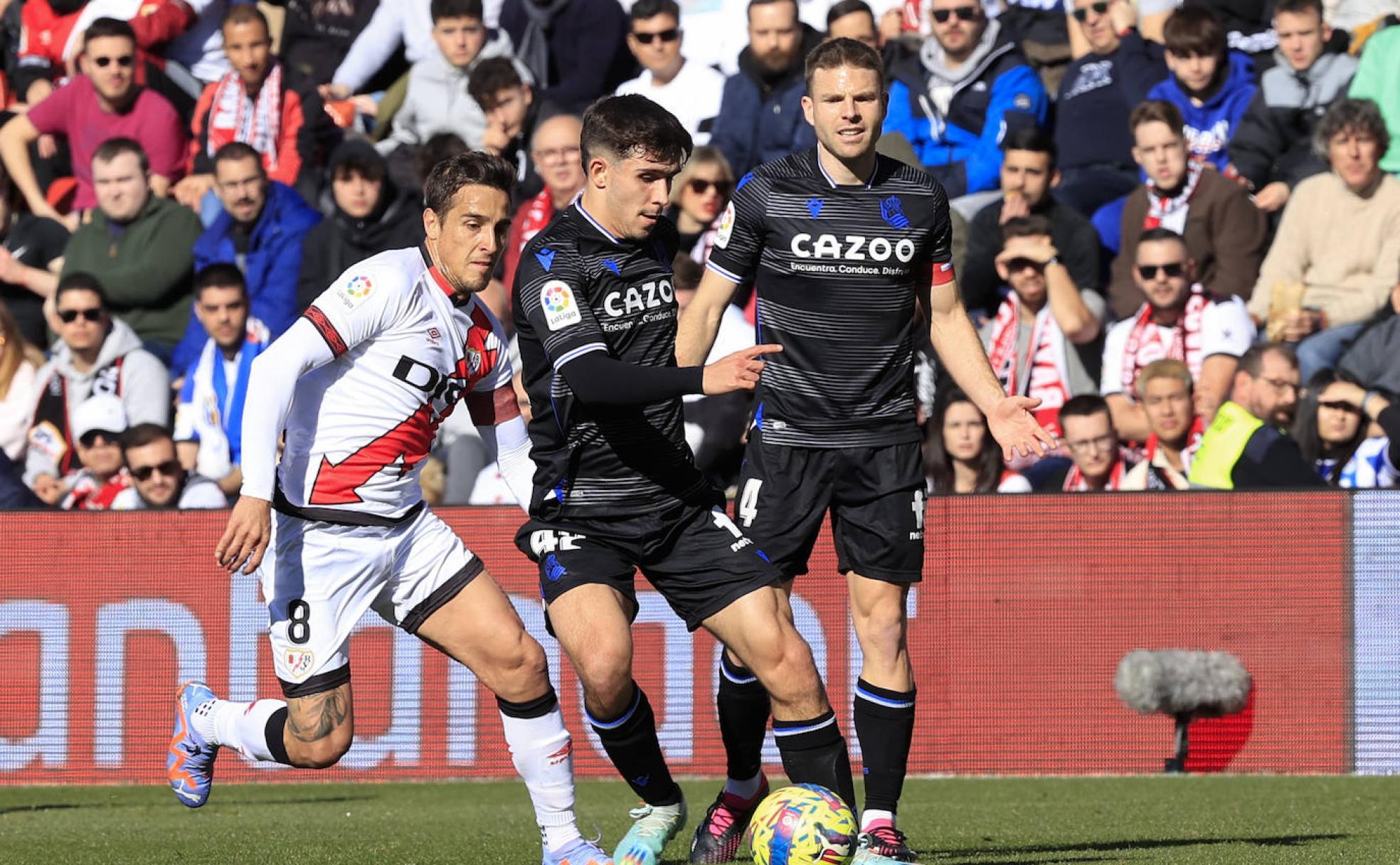Pablo Marín conduce un balón ante la presión de Óscar Trejo y la mirada de Illarramendi. 