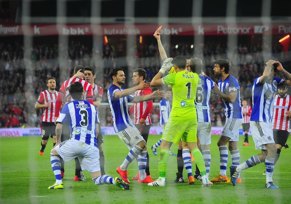 Los jugadores de la Real, incrédulos ante la roja que Martínez Munuera mostró a Mikel González en el derbi del 28 de abril de 2015.