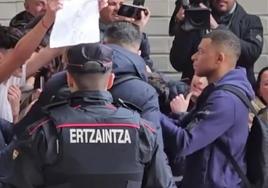 Kylian Mbappé observa la cartulina con el escudo madridista que regateo firmar en el aeropuerto de Hondarribia.