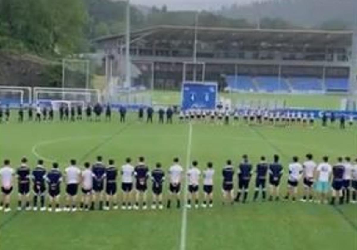 Jugadores y técnicos de la cantera de la Real Sociedad guardan un minuto de silencio.