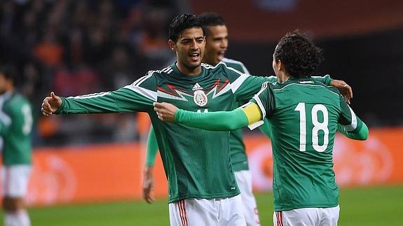 Carlos Vela y Andrés Guardado celebran un gol de la selección de México.