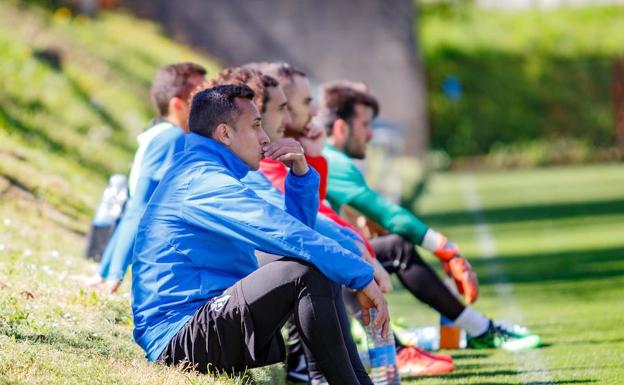 Varios jugadores del Eibar, con Orellana y Cucurella al frente, observan sentados un ejercicio de sus compañeros. 