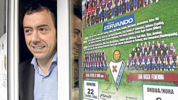 El presidente Álex Aranzabal se asoma en la puerta de las oficinas del club en Ipurua con el cartel del encuentro de mañana.
