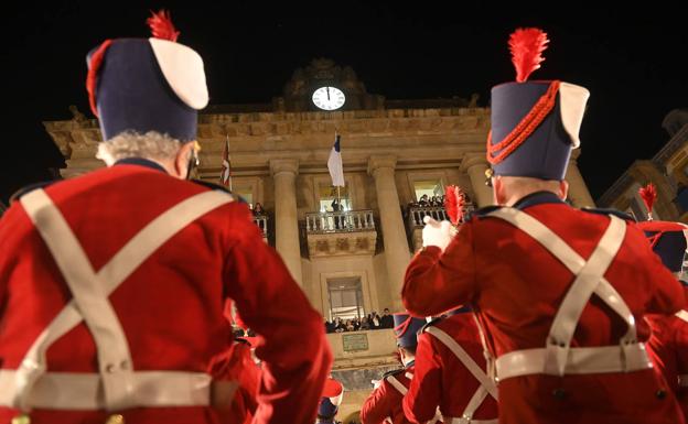 La Unión Artesana toca La Marcha de San Sebastián mientras Eneko Goia, desde el balcón de la plaza de la Constitución, arría la bandera de la ciudad.