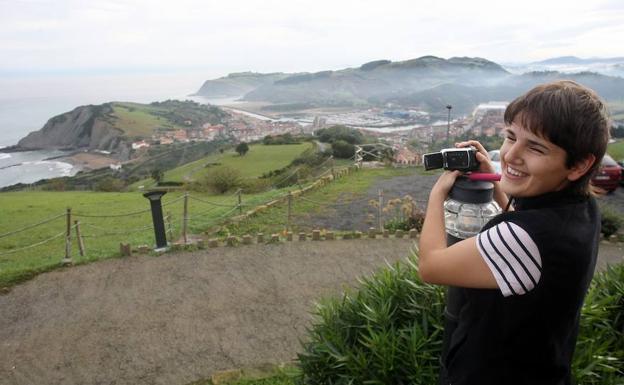 Imagen principal - Arriba, Maite Mancisidor graba la playa desde el Agroturismo Santa Klara. A la izquierda, imagen de los trabajos de grabación en Itzurun. A la derecha, imagen del equipo de la serie durante un descanso. 