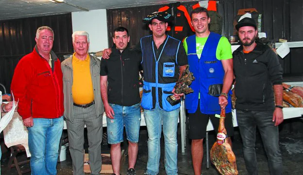 Los ganadores de la tirada al pichón con sus correspondientes trofeos y premios. 