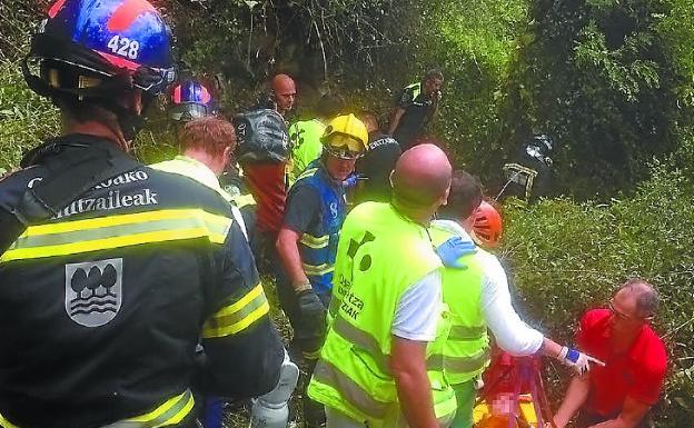 Bomberos, sanitarios y ertzainas junto a la camilla con la joven que resultó herida.