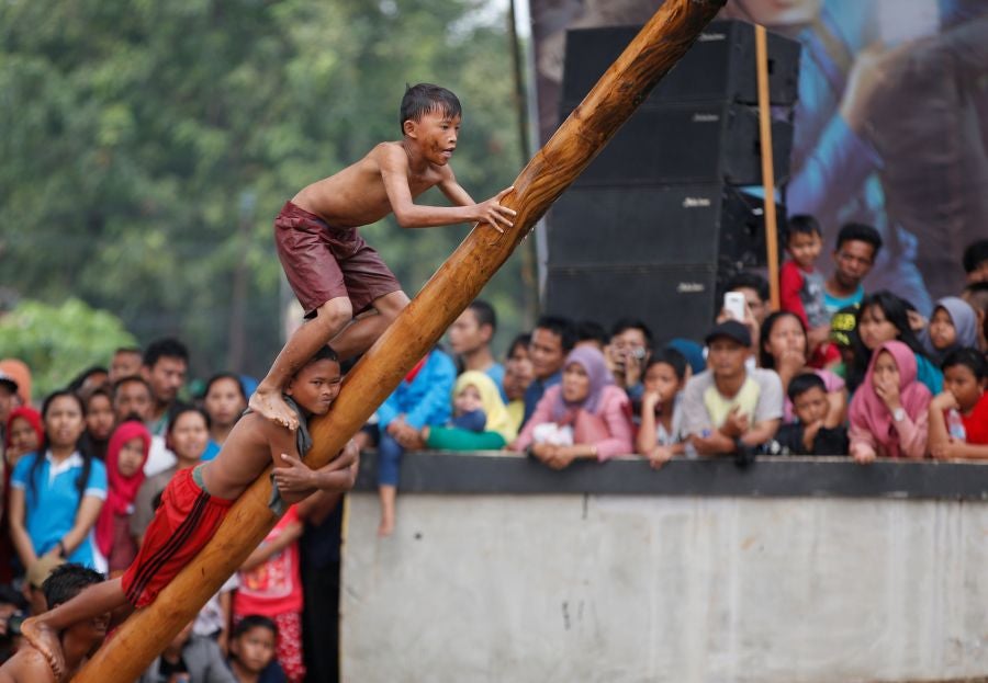 Indonesia celebra su 72 aniversario de independencia y por ello, a lo largo del territorio, se celebra la tradicional 'Panjat Pinang'. En una explanada se colocan arboles tallados, previamente lubricados con regalos en la parte más alta y los nativos deben alcanzar la cima para conseguir los presentes.