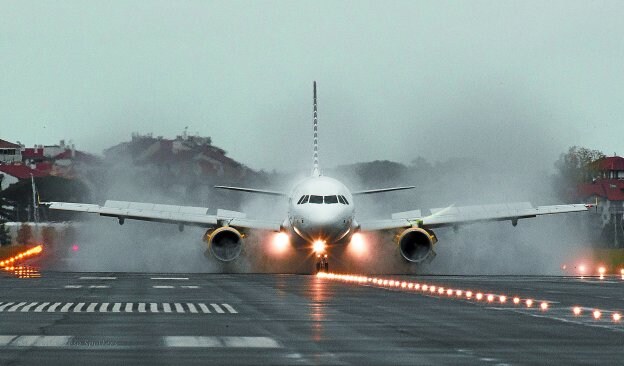 Imagen de un Airbus A-319 de la compañía Vueling maniobrando sobre la pista del aeropuerto de Hondarribia un día lluvioso.