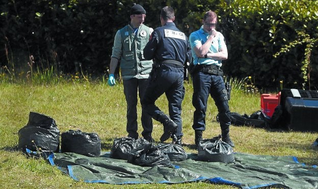 Policías custodian bolsas con armas, en un zulo de Senpere, el pasado abril. 
