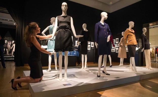 Una empleada de Christie's coloca el vestido de cóctel en satén negro, de Givenchy, que Hepburn lució en 'Charada'. 