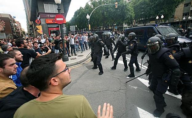 Agentes de la policía nacional forman un cordón policial en el exterior del IES de Tarragona.