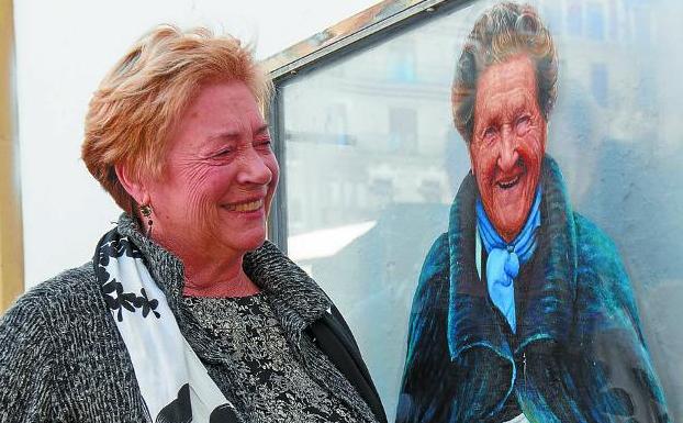 Del tronco sale, sale la rama... Agurtzane, 75 años, cinturón negro de karate, cigarrera y costurera, junto al retrato de su madre, Andresa. 