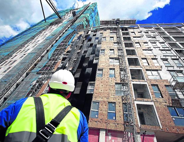 Un operario observa la construcción de un bloque de viviendas.