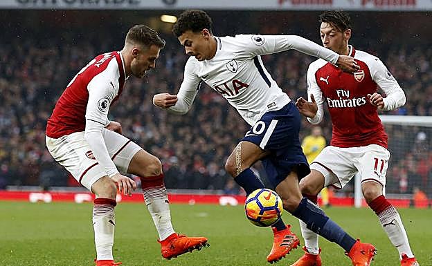 Dele Alli encara a dos jugadores del Arsenal.