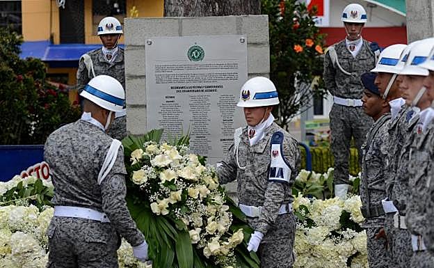 Militares colombianos colocan una corona de flores en el mural dedicado a las víctimas. 