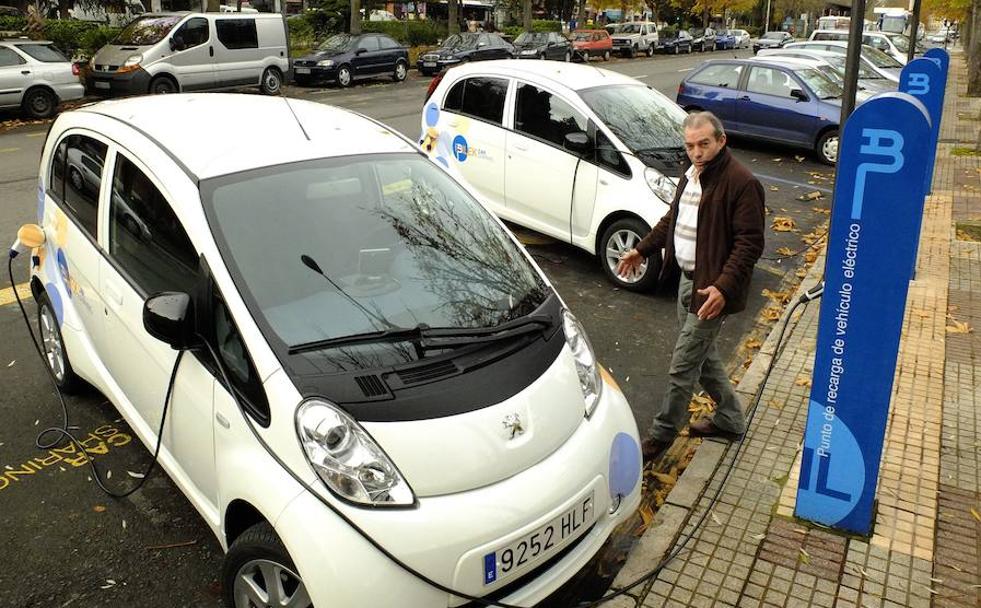 Un usuario de coche eléctrico recarga su vehículo en una calle de Vitoria.