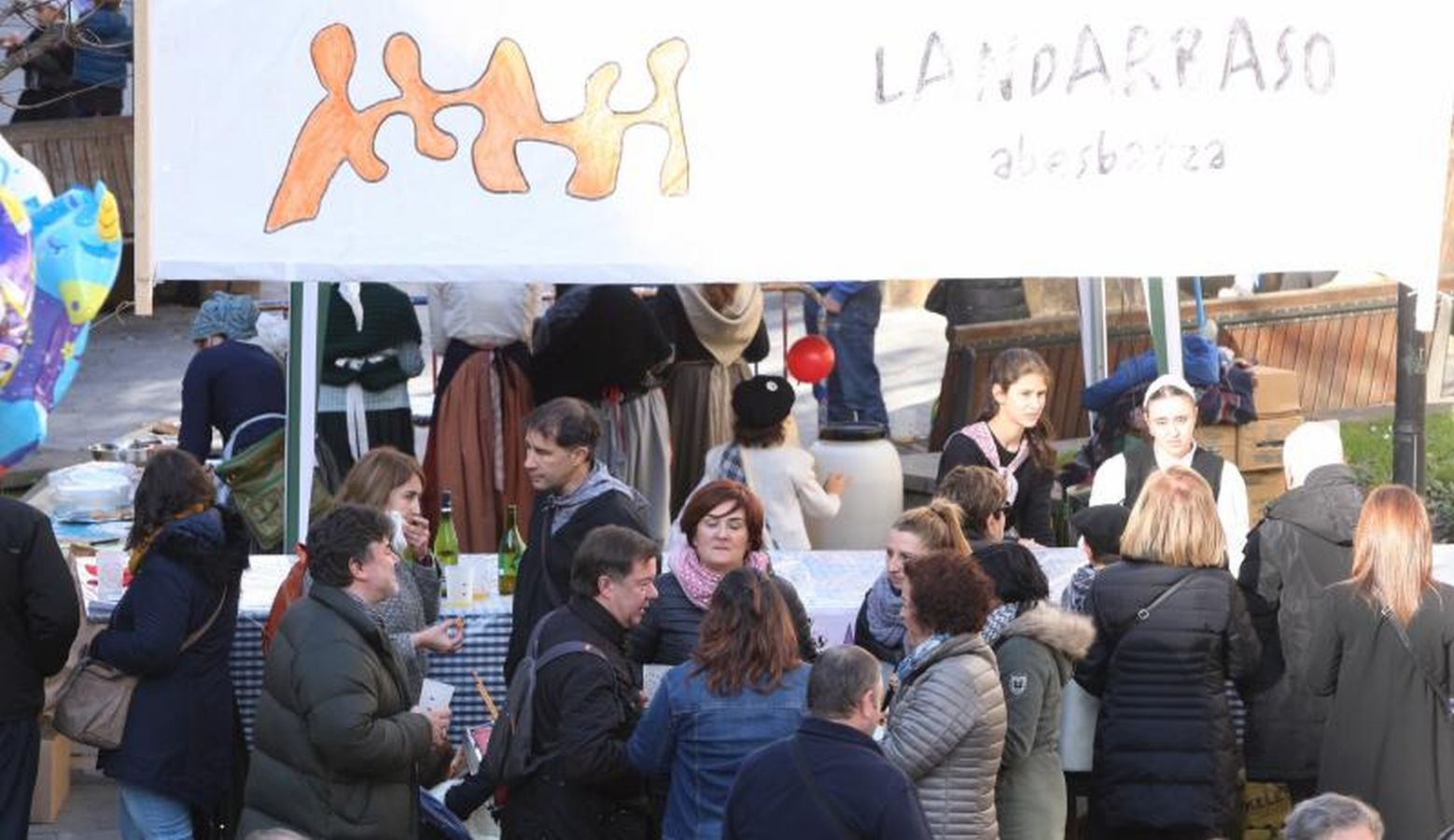 Mayores y niños disfrutan de los talos y la txistorra que se ofrecen en lo diferentes puestos de la localidad