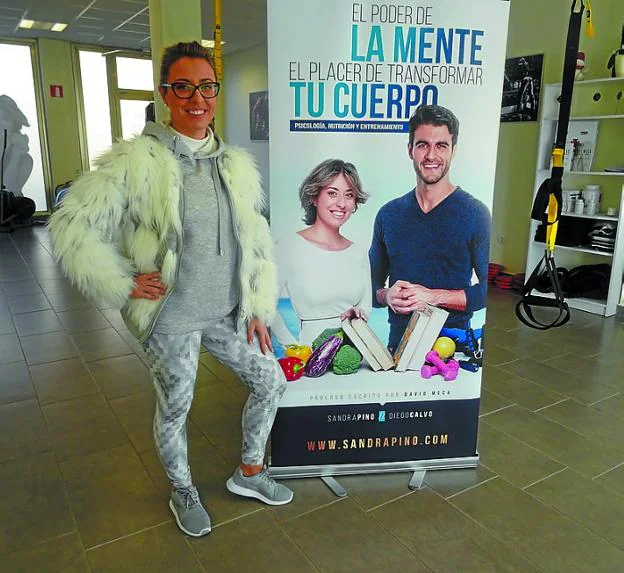 Sandra Pino. En su estudio, ante la portada del libro. 