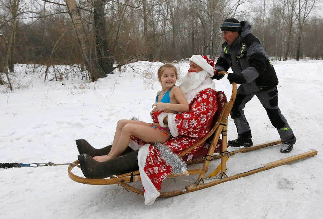 Miembros del club de nadadores de invierno Cryophile amateurs y sus hijos, acompañados por el padre Frost, el equivalente ruso de Santa Claus, se dan un baño en el río Yenisei, Rusia. Esta es su forma de celebrar la llegada de la Navidad y el Año Nuevo.