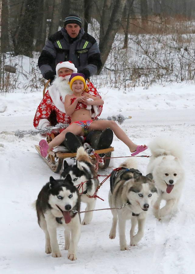 Miembros del club de nadadores de invierno Cryophile amateurs y sus hijos, acompañados por el padre Frost, el equivalente ruso de Santa Claus, se dan un baño en el río Yenisei, Rusia. Esta es su forma de celebrar la llegada de la Navidad y el Año Nuevo.