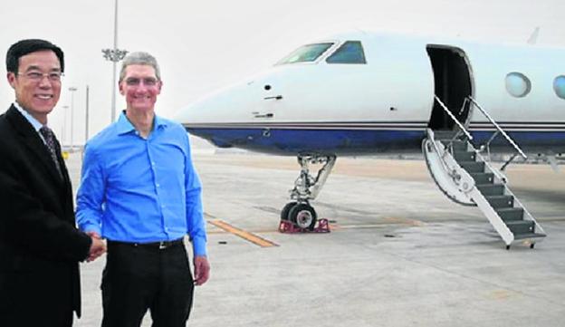 El consejero delegado de Apple, Tim Cook (derecha), se despide antes de subir a su avión.