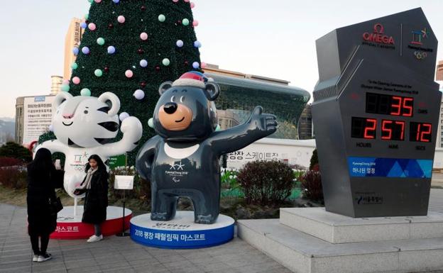Dos jóvenes se toman fotos junto a las esculturas de las mascotas de los Juegos de Pyeongchang 2018. 