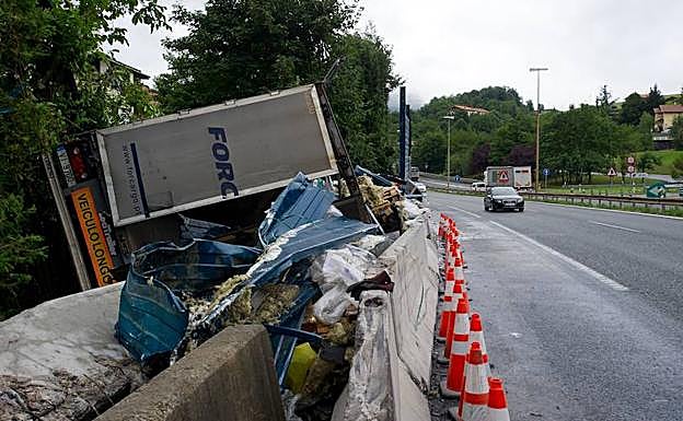 El camión se salió de la calzada y quedó volcado en la cuneta tras el accidente.