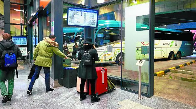 Varios pasajeros esperan la llegada del autobús en la nueva estación de Donostia.