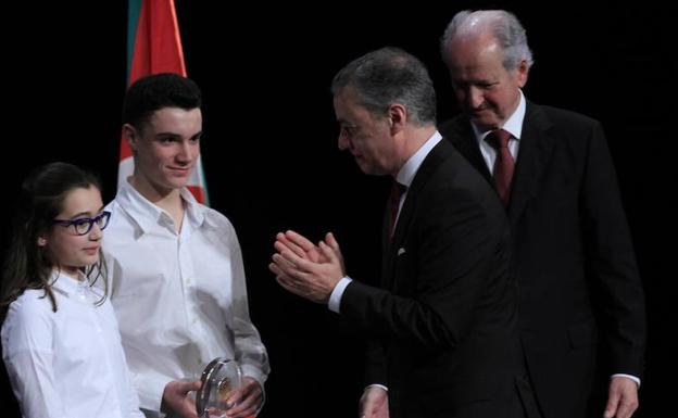 El lehendakari Urkullu, acompañado de Juan María Atutxa, entrega el premio a los dos jóvenes en representación de la campaña 'No es no'.