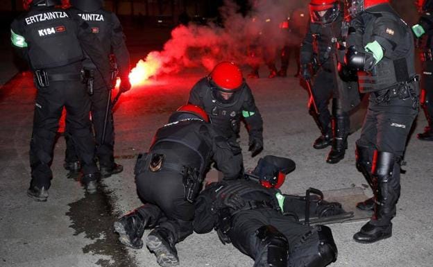 Los agentes atienden a su compañero, que yace en el suelo.