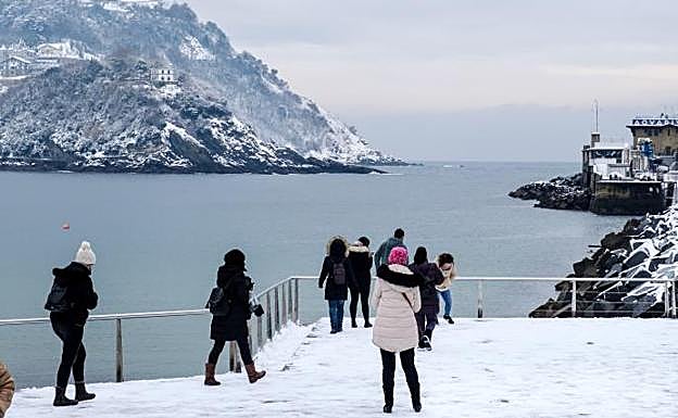 Numerosas personas se acercaron a la terraza del Club Náutico para contemplar la estampa de la bahía de Donostia nevada. 