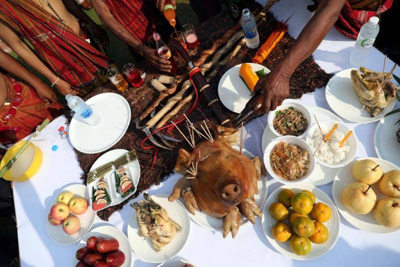 La gente alimenta a los elefantes antes de un partido en el Torneo de Polo de Elefante de la Copa del Rey en un resort ribereño en Bangkok