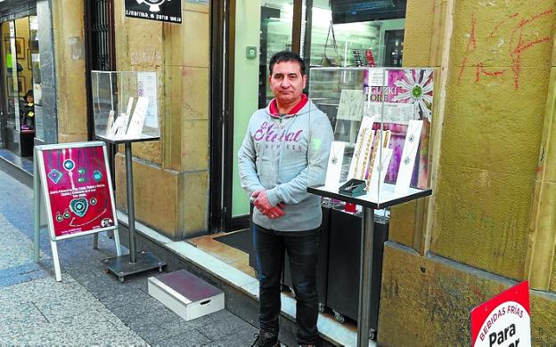 Carlos, junto a los expositores de su tienda en la calle Narrika.