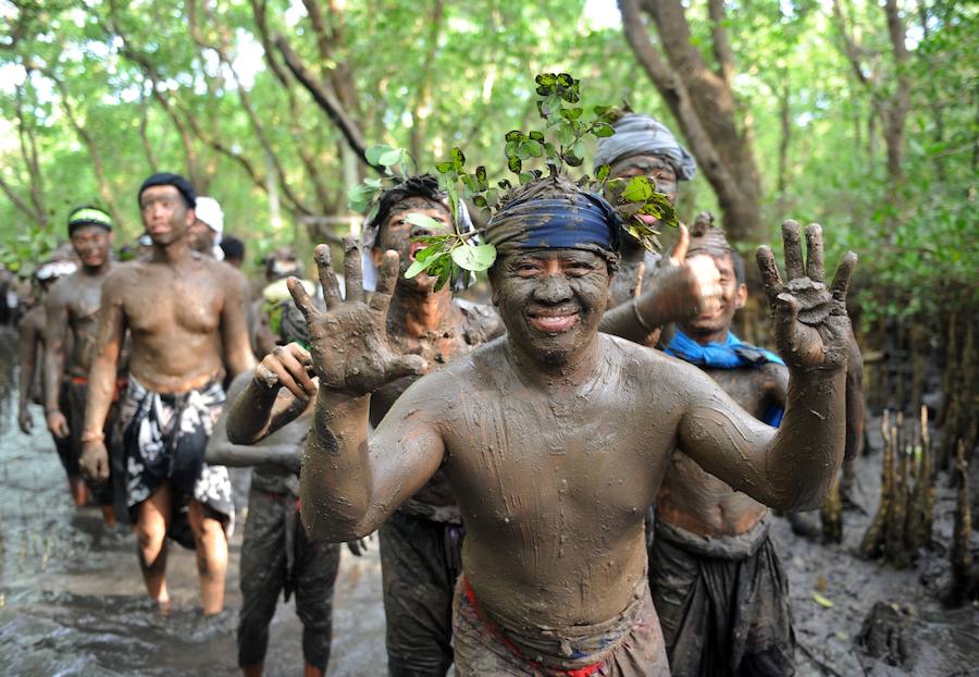 Niños y mayores se esparcen barro por todo su cuerpo durante el tradicional baño de barro conocido como Mebuug.buugan en la aldea de Kedonagn, cerca de Denpasar, en la isla balnearia indonesia de Bali.