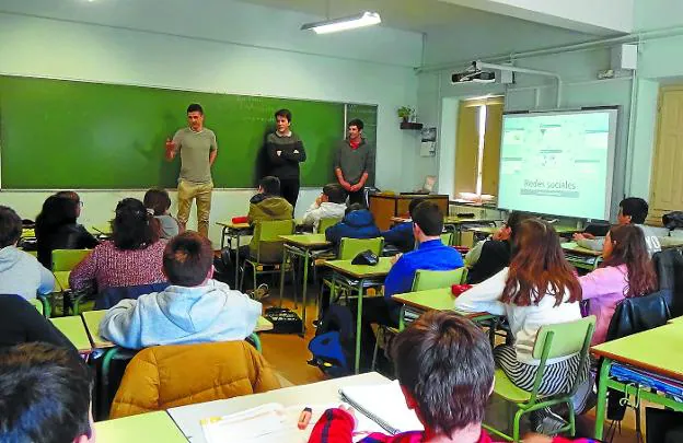 Tres alumnos de la universidad de Técnun asesoran sobre el uso de las redes sociales a un grupo de adolescentes del colegio Larramendi.