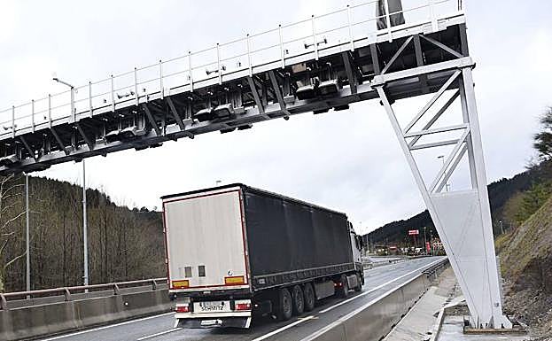 Un camión circula bajo uno de los arcos del peaje.