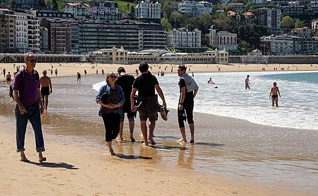 La gente ha paseado y bañado en la playa de La Concha.
