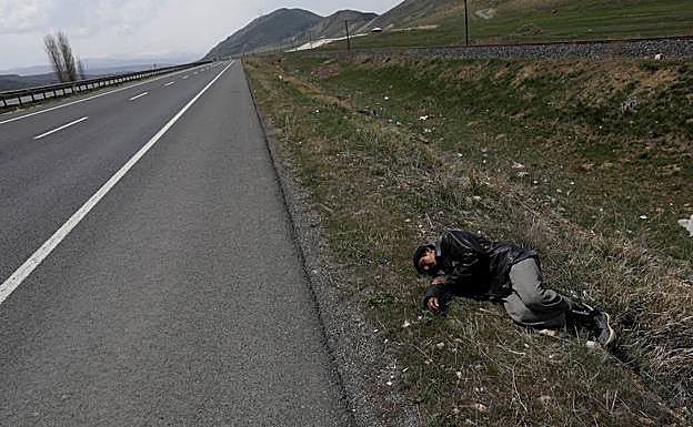 Un migrante afgano descansa en la cuneta de la carretera antes del accidente. 