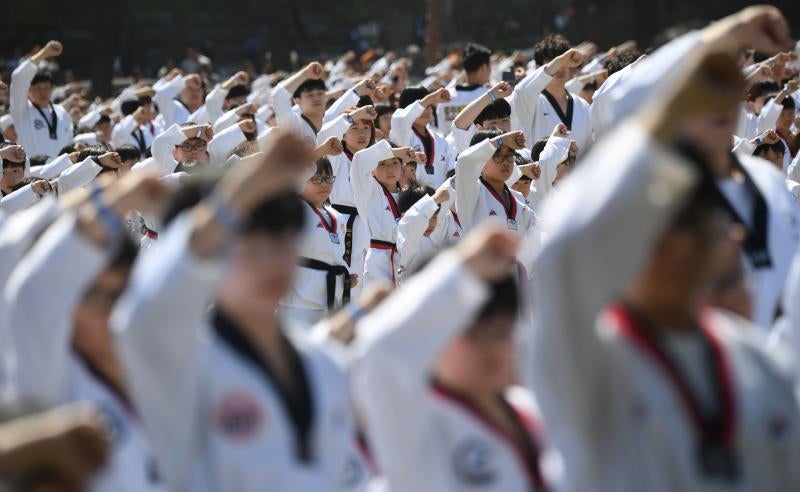 Diez mil deportistas de Taekwondo participan en una exhibición, delante del edificio de la Asamblea Nacional de Corea del Sur, en Seúl, para celebrar la declaración de este arte marcial como deporte oficial patrocinado por el Estado y para intentar marcar un nuevo récord Guinness de participantes. 